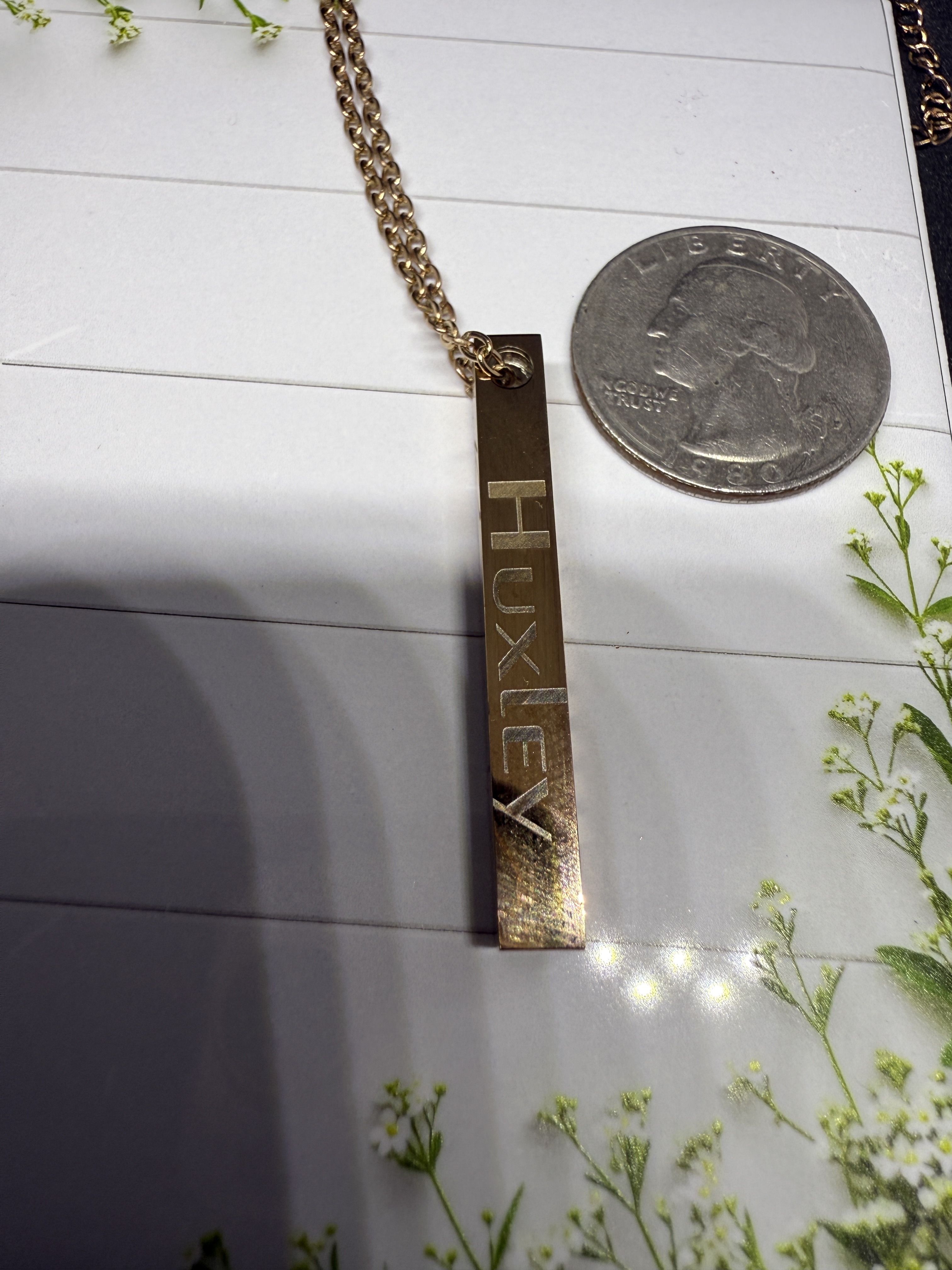 A pair of rose gold metal cufflinks in a dark wood box with compartments.