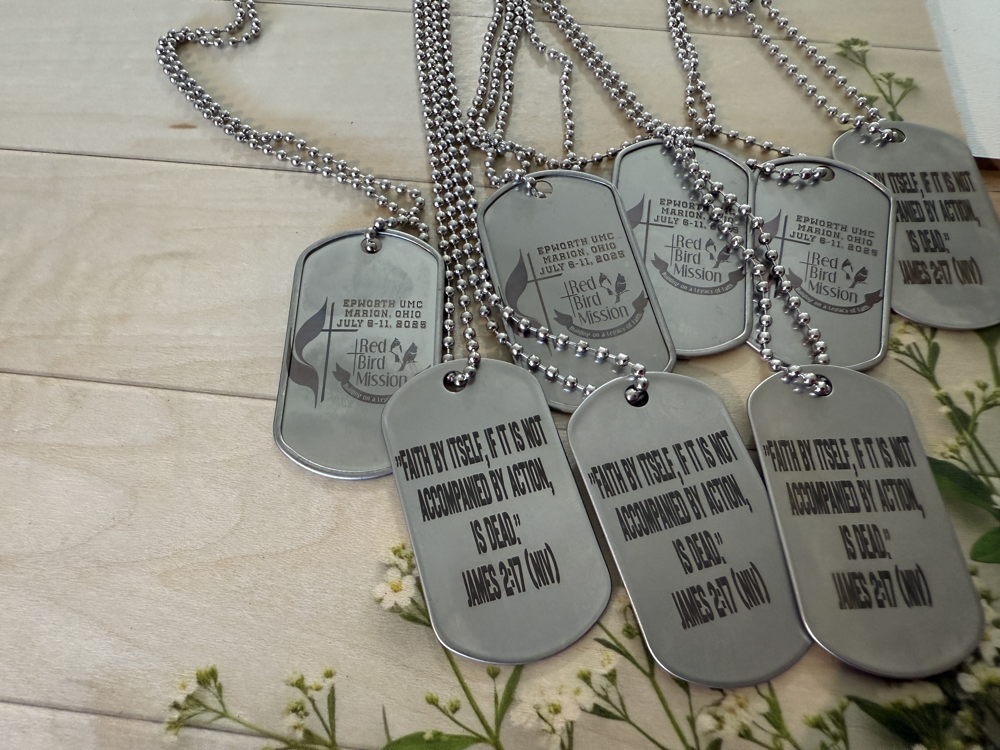 Brass letters, 'V' and 'L' focusing on 'V', with a reflective surface on a plastic cube, possibly jewelry.