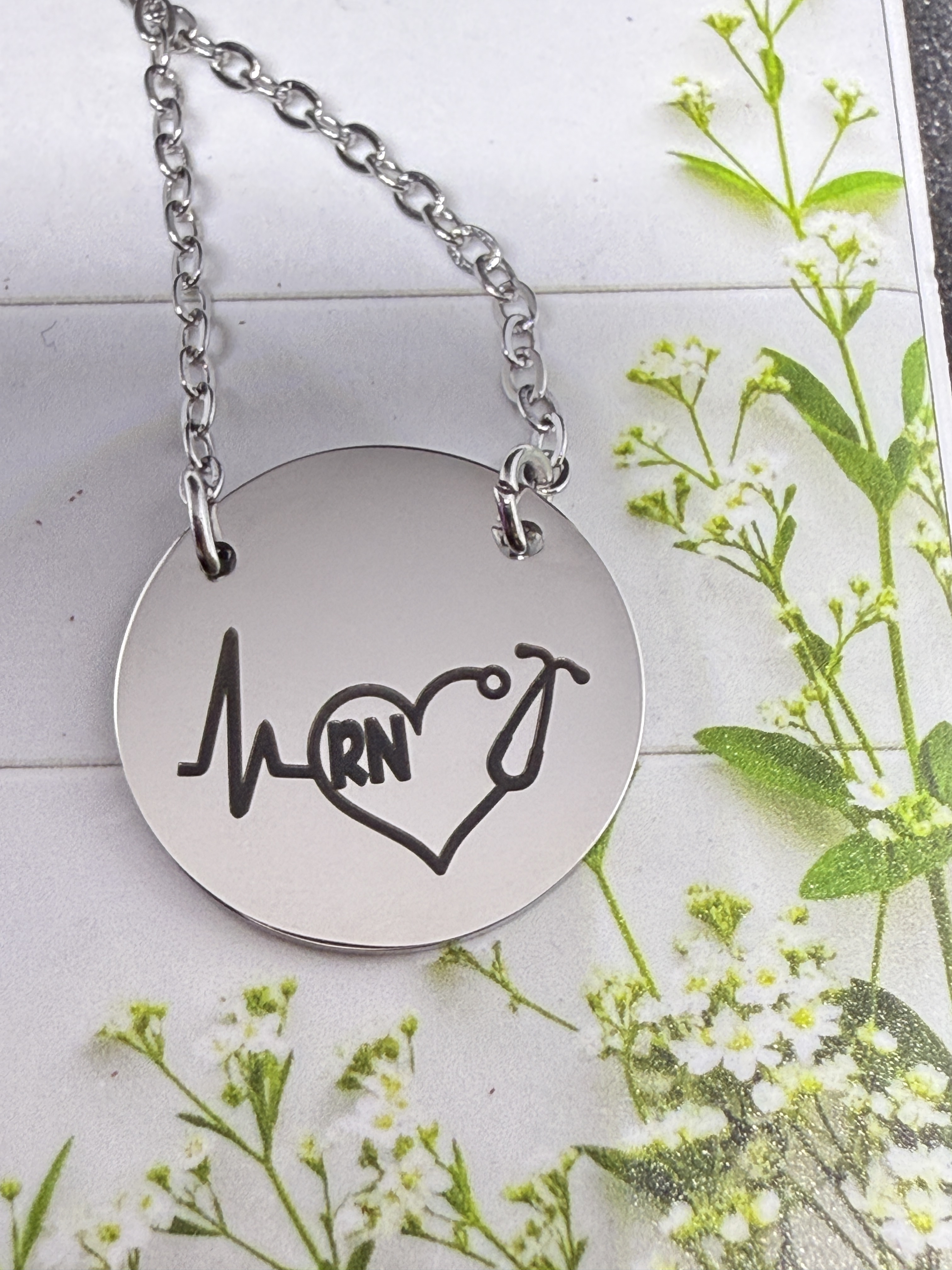 The image presents a locket adorned with a message inside, displayed on a surface featuring an ornate mirror frame in the ...